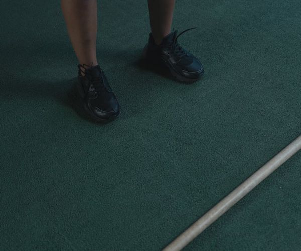 Close up of sneakers and gym equipment on a dark reflective floor